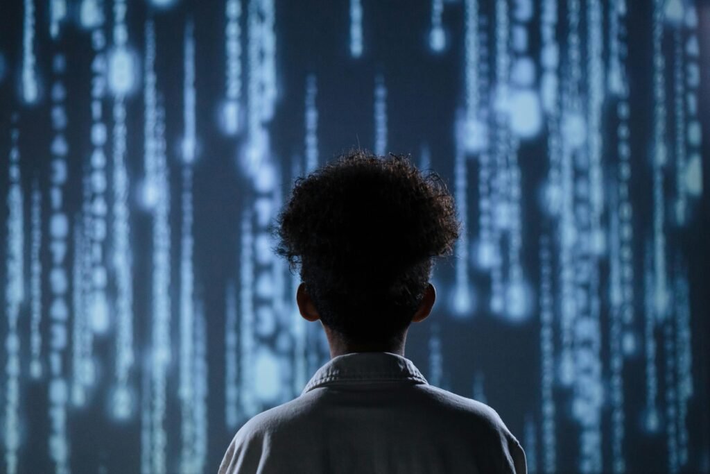 pexels-photo-9783353-9783353 A young boy viewing a digital screen with data streams, symbolizing technology interaction.